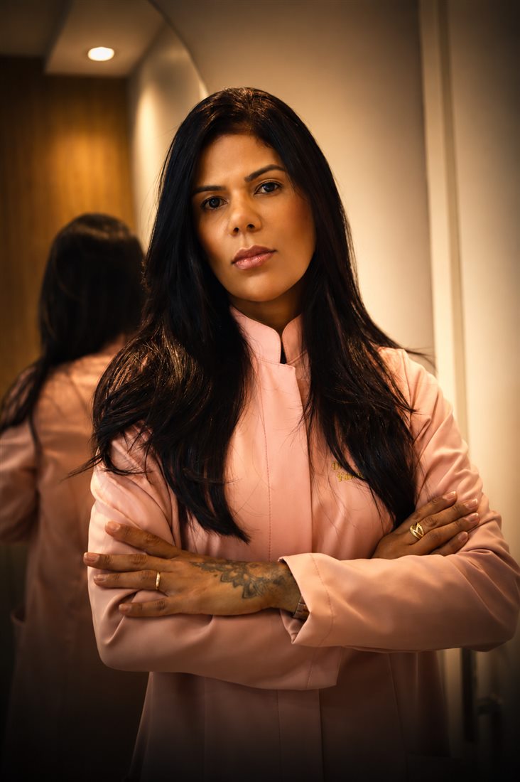 Dra. Natalia Oliveira, farmacêutica clínica e tricologista, em pé no consultório